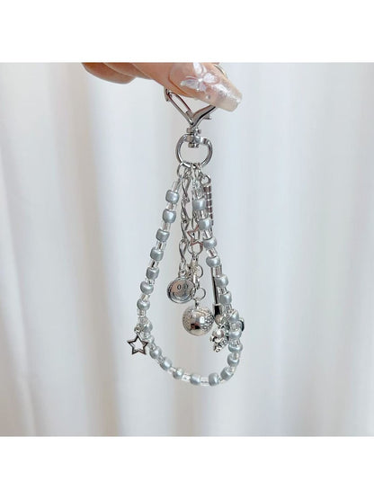 Close-up of textured golf ball charm attached to silver keyring