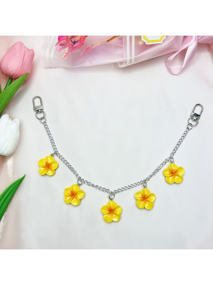 Close-up of gold clasp connecting flower pendant to bag charm chain
