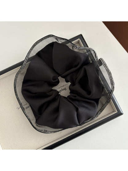 Gifty scrunchie in beige fabric with subtle sheen, highlighting its chic minimalist design