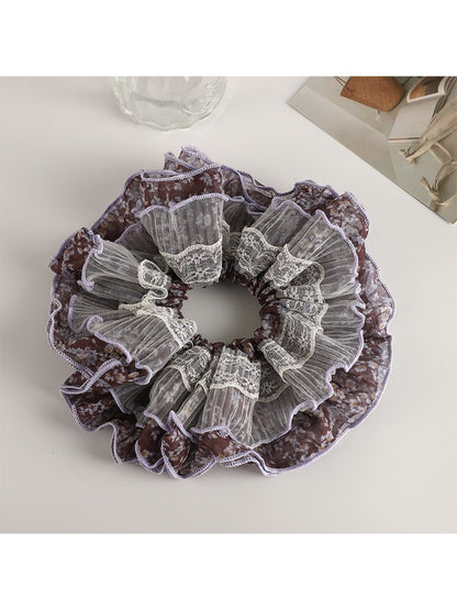 Vintage purple floral scrunchie styled with casual outfit on a wooden surface