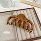 Beau textured shark hair claw clip angled to show both sides and teeth