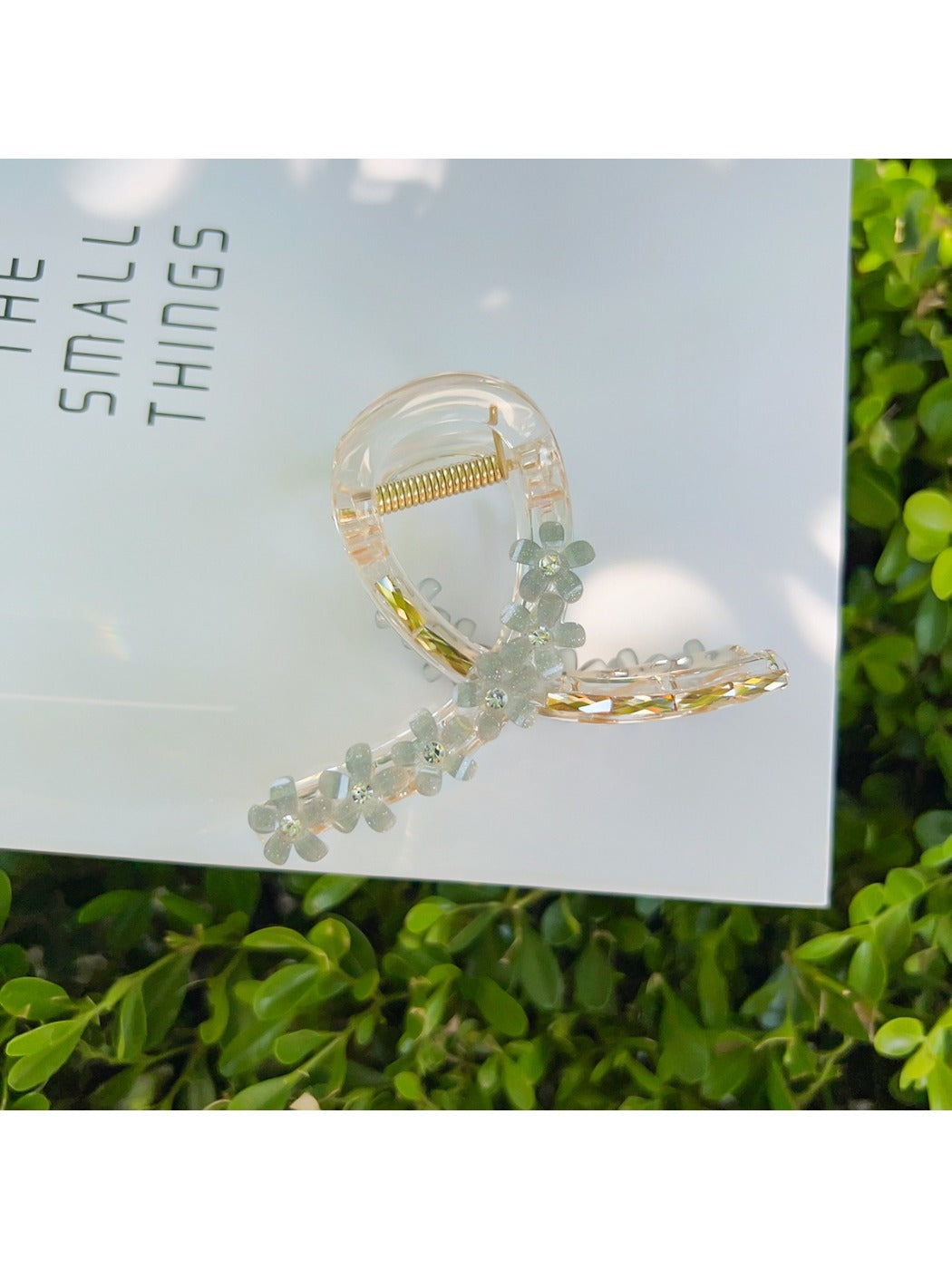 Beau flower crisscross hair claw clip on white surface with shadows