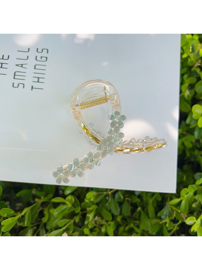 Beau flower crisscross hair claw clip on white surface with shadows