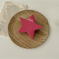 Beau star shaped claw clip resting on fabric surface for contrast
