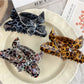 Top view of Beau leopard print claw clip highlighting butterfly embellishment