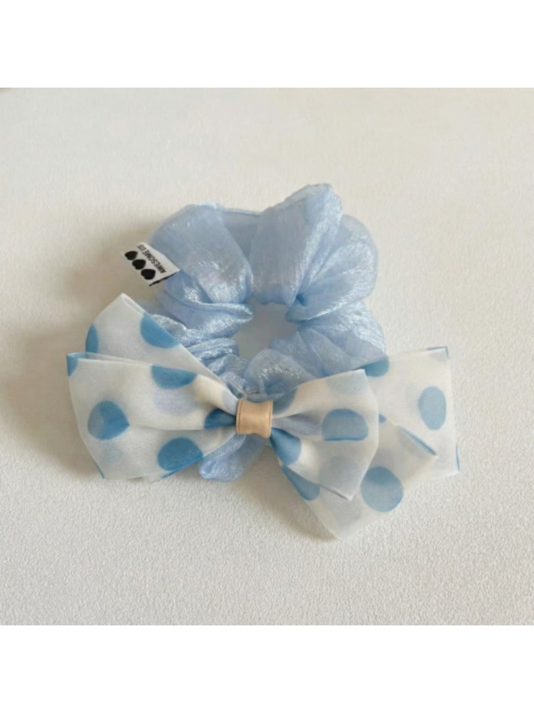 Polka dot bow hair tie styled in a ponytail on a model