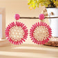 Sunflower drop earring held between fingers showing size and detail