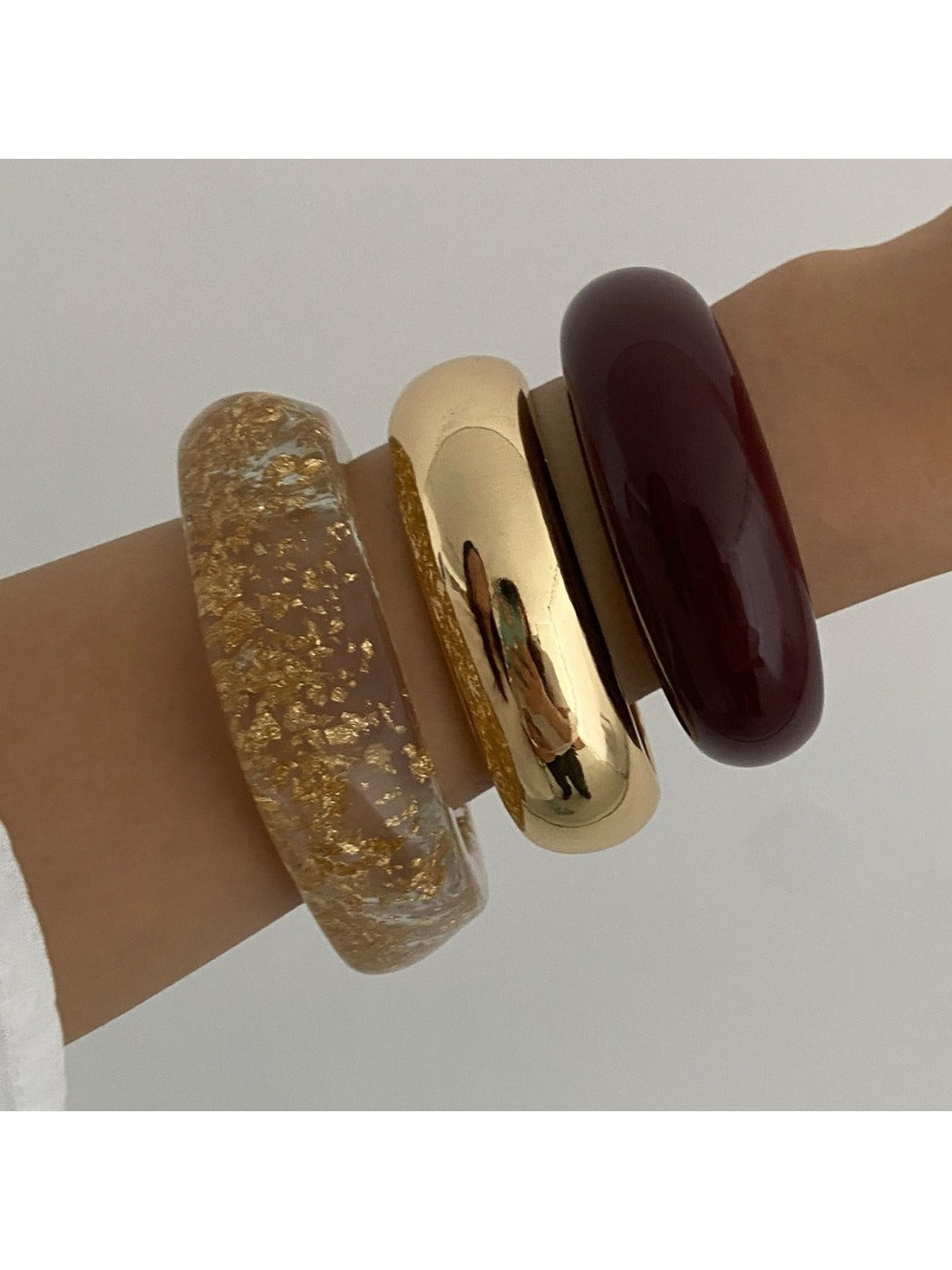 Multiple Lovra bracelets stacked together showcasing their polished metal texture