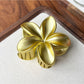 Beau flower shaped claw clip resting on fabric surface