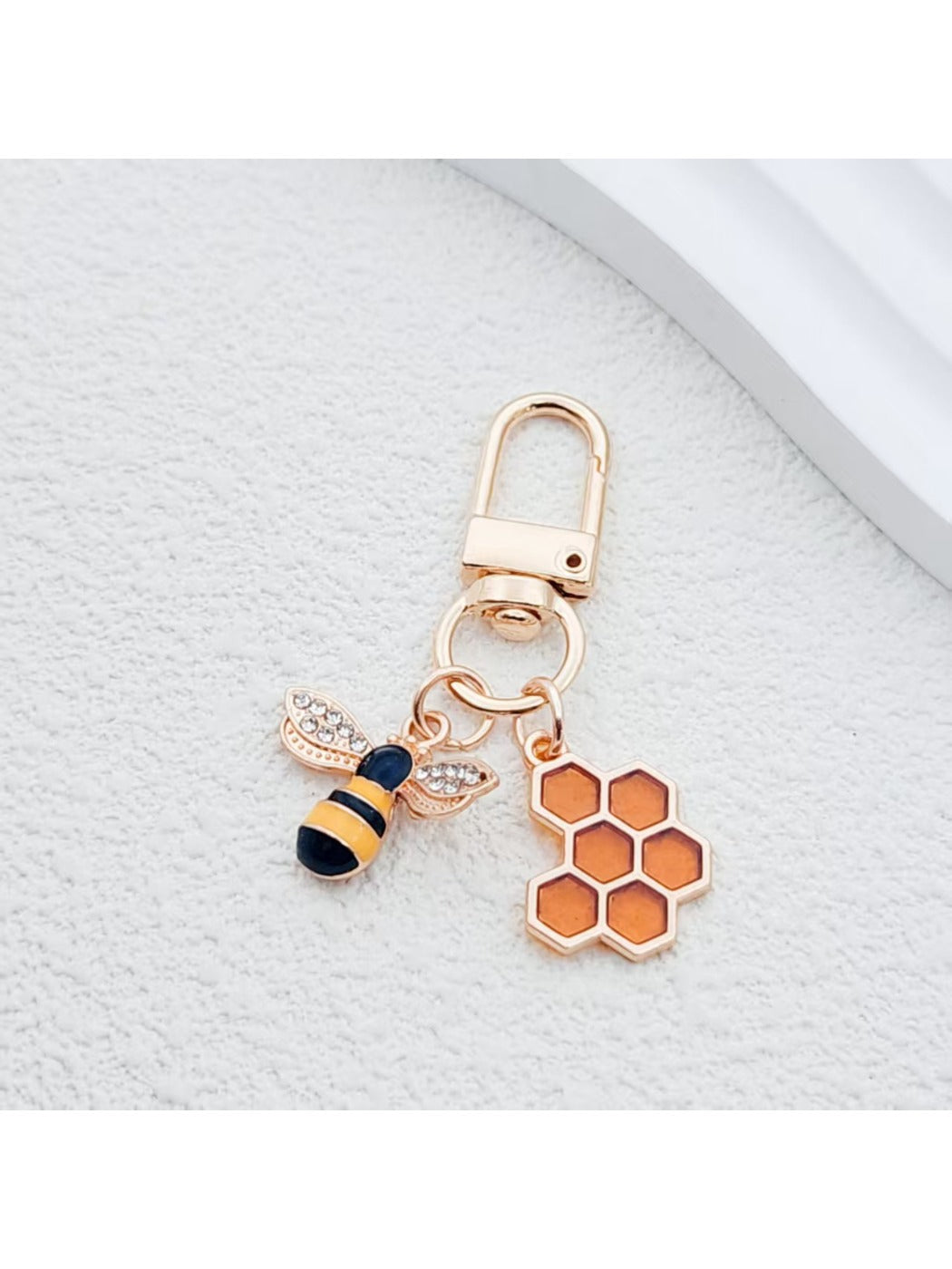 Bee and honeycomb keychain hanging from a set of keys