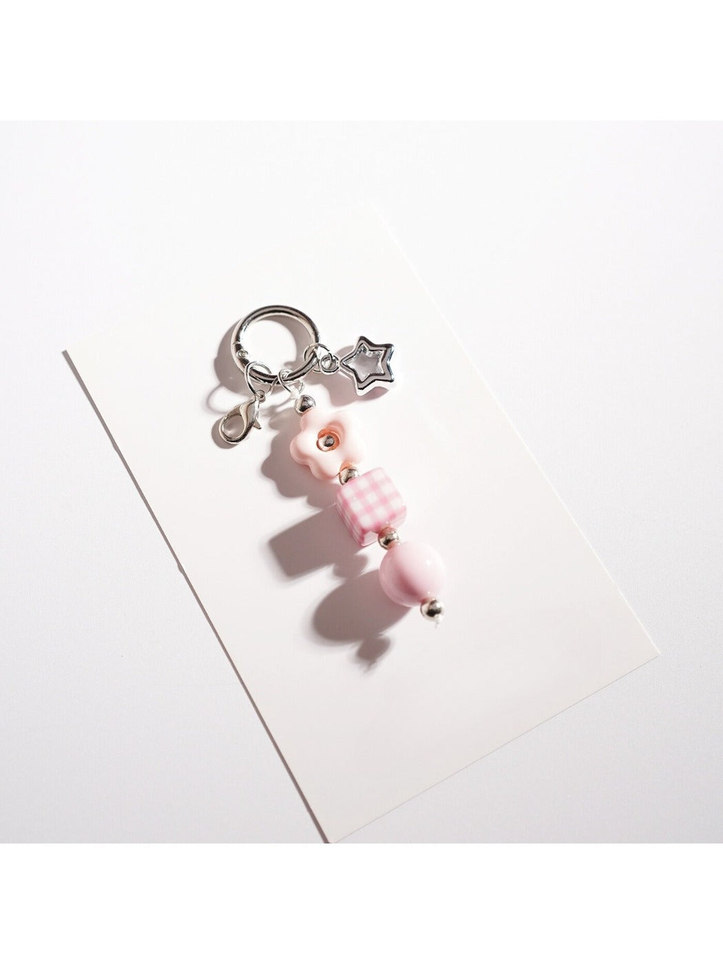 Beaded star keychain resting on a notebook with a pen nearby