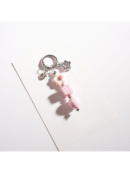 Beaded star keychain resting on a notebook with a pen nearby