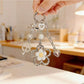 Flower charm keychain hanging from a hand, showcasing its modern minimalist design