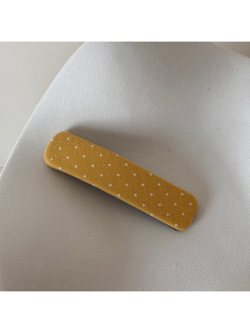 Beau hair clip angled to show both front polka dot design and back clasp