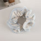 Top view of Gifty floral scrunchie with soft pink tulle ruffles and flower patterns