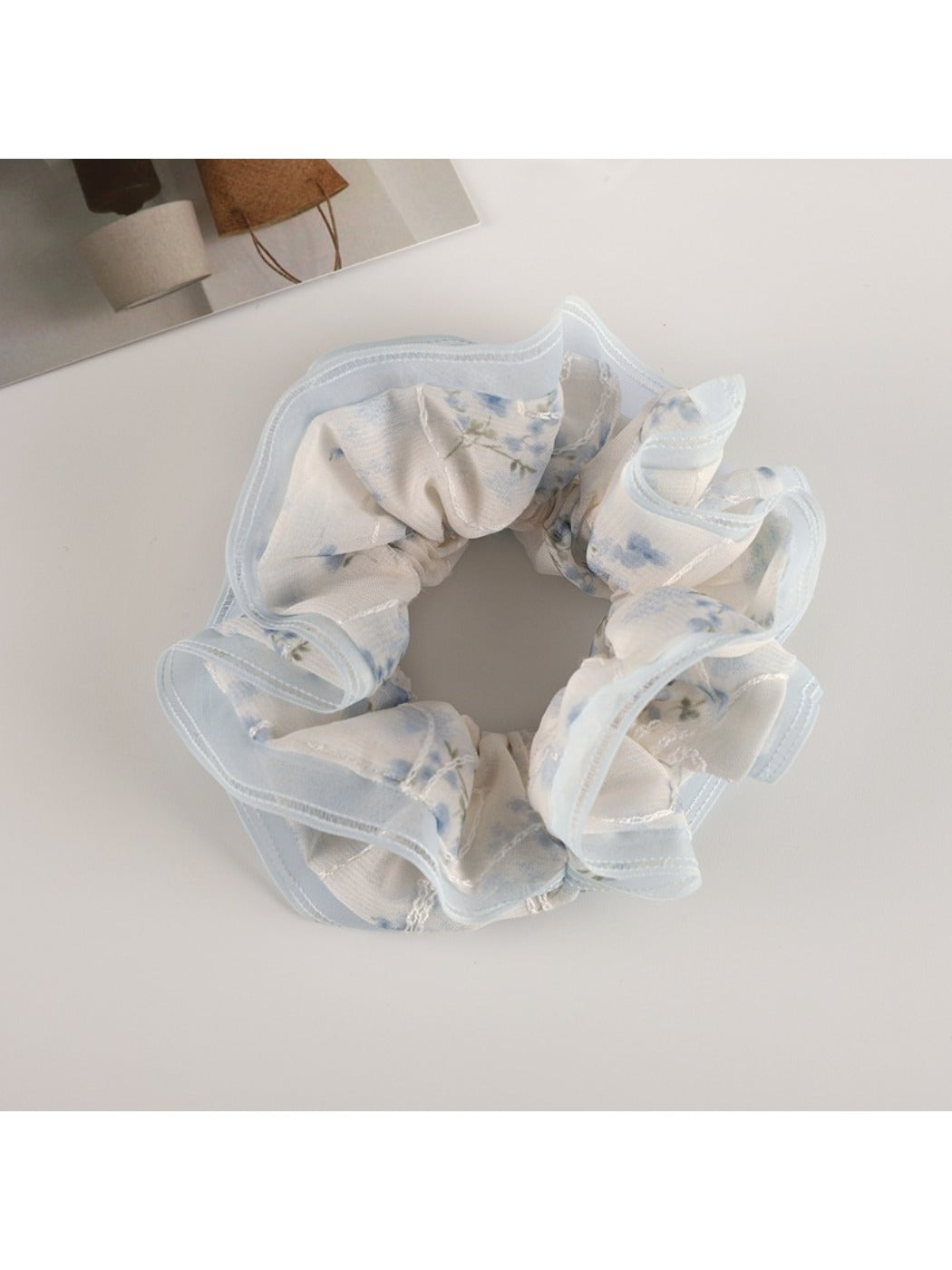 Top view of Gifty floral scrunchie with soft pink tulle ruffles and flower patterns