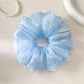 Close-up of Gifty ruched scrunchie showing fabric texture and elastic band