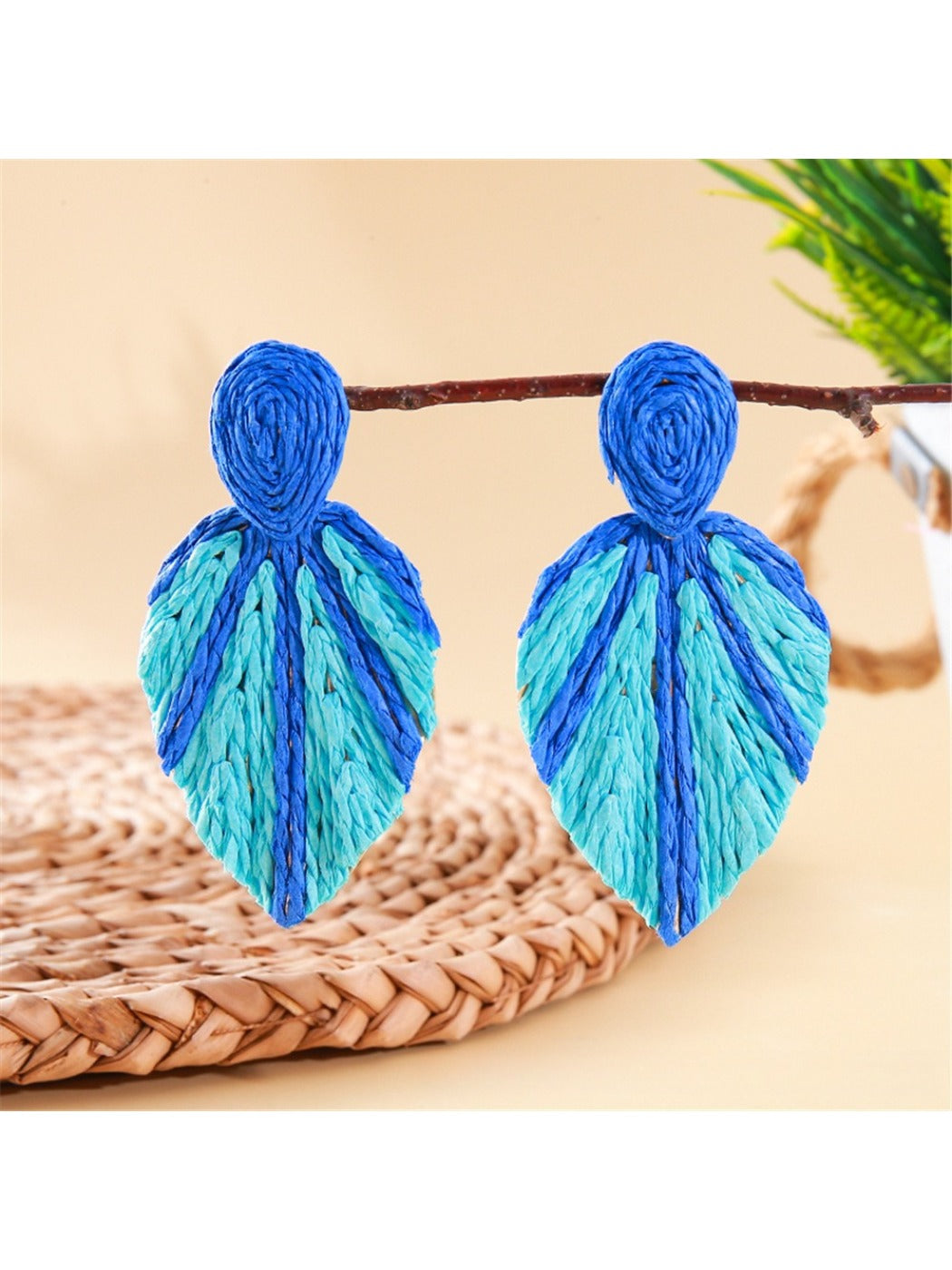 Side view of raffia woven leaf shaped earrings showing texture and weave