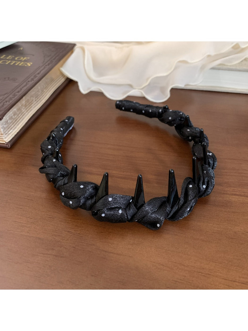 Gifty satin polka dot headband placed on a wooden surface for display