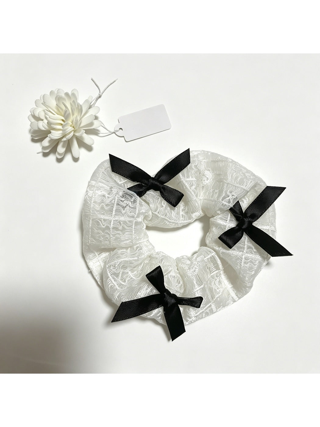 Gifty lace scrunchie wrapped around a ponytail on a model's hair