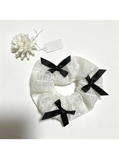 Gifty lace scrunchie wrapped around a ponytail on a model's hair