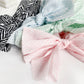 Close-up of striped bow detail on beige and white scrunchie