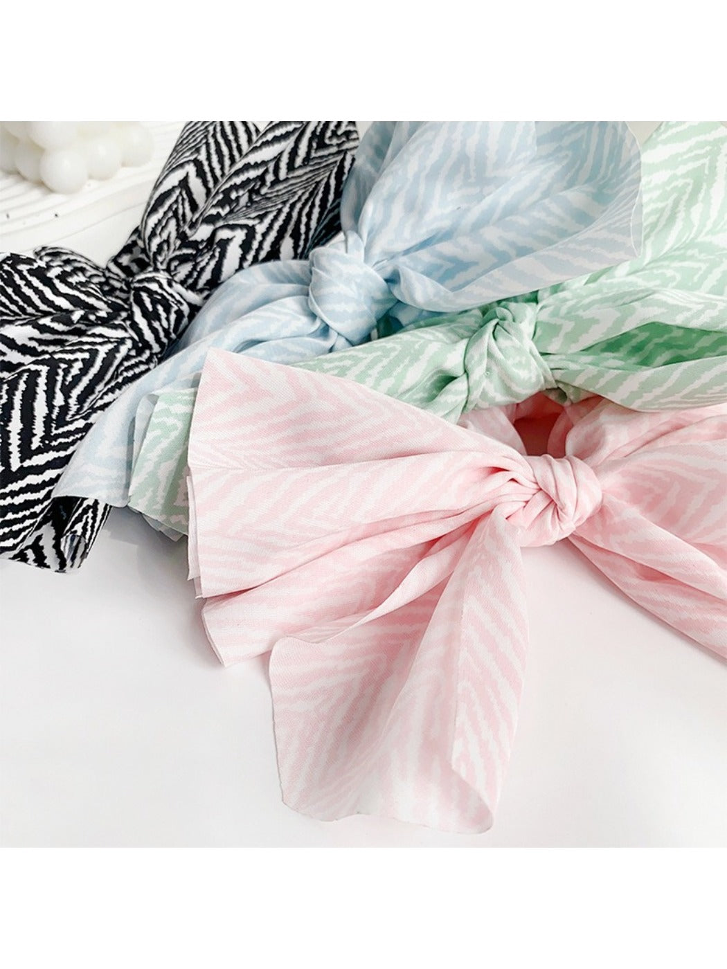 Close-up of striped bow detail on beige and white scrunchie