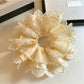 Close-up of beige tulle scrunchie showing intricate lace detailing