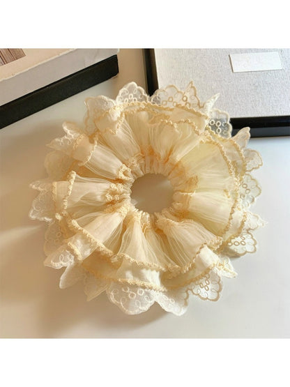 Close-up of beige tulle scrunchie showing intricate lace detailing