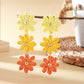 Close-up of earring hooks attached to colorful flower shaped drops