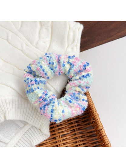 Model wearing a colorful scrunchie in her hair with matching headbands