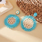 Pair of sunflower shaped drop earrings displayed on a white background
