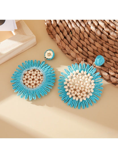 Pair of sunflower shaped drop earrings displayed on a white background