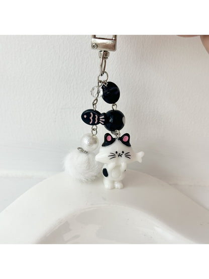 Set of cat and fish keychains attached to a backpack zipper pull