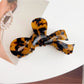 Beau delicate bow hair claw clip styled in a half-up hairstyle on model