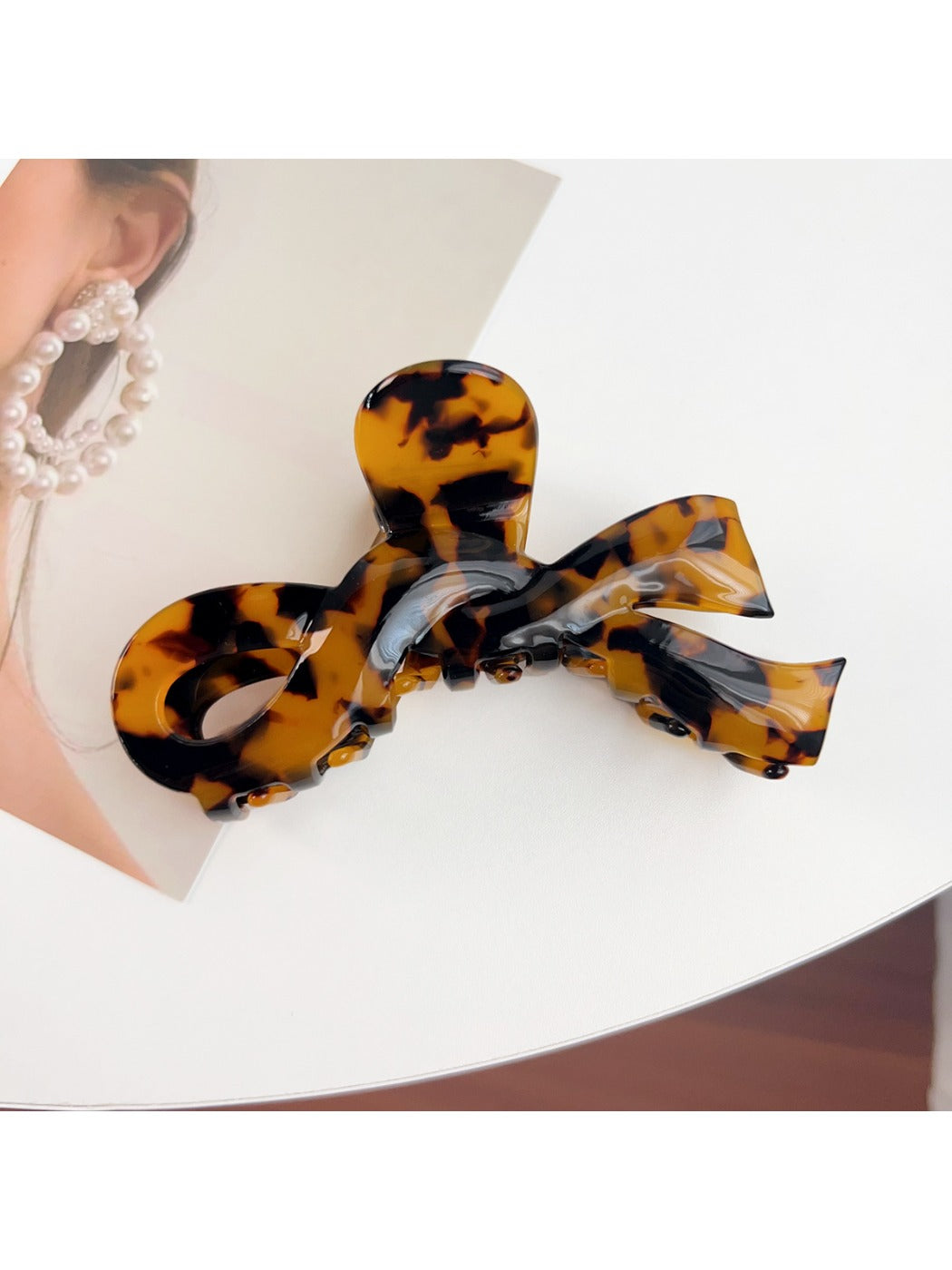 Beau delicate bow hair claw clip styled in a half-up hairstyle on model