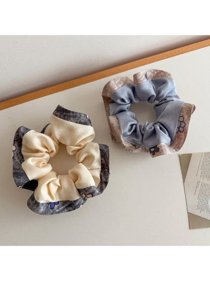 Gifty scrunchie worn on a wrist highlighting ruffle detail and multicolor pattern