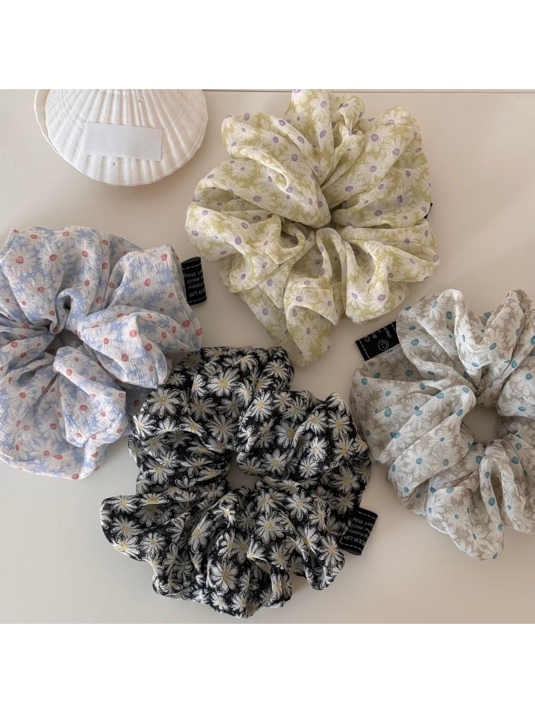 Gifty scrunchie worn on a wrist, showcasing its size and daisy design