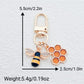 Bee and honeycomb keychain displayed on wooden surface