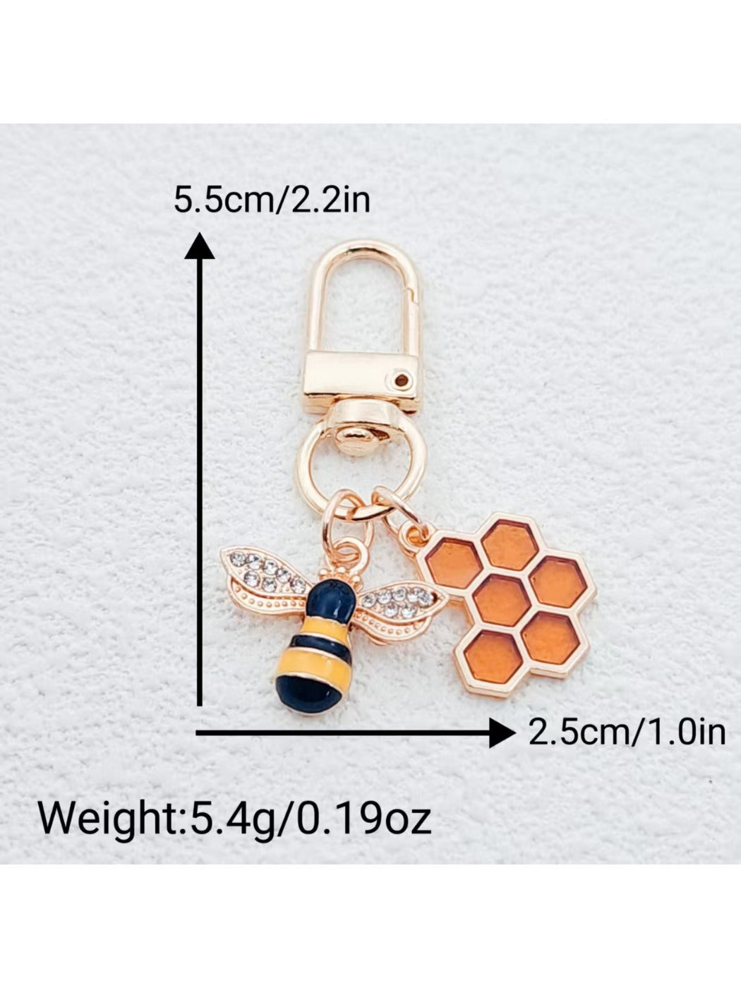 Bee and honeycomb keychain displayed on wooden surface