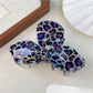 Beau leopard print bow claw clip placed on wooden surface