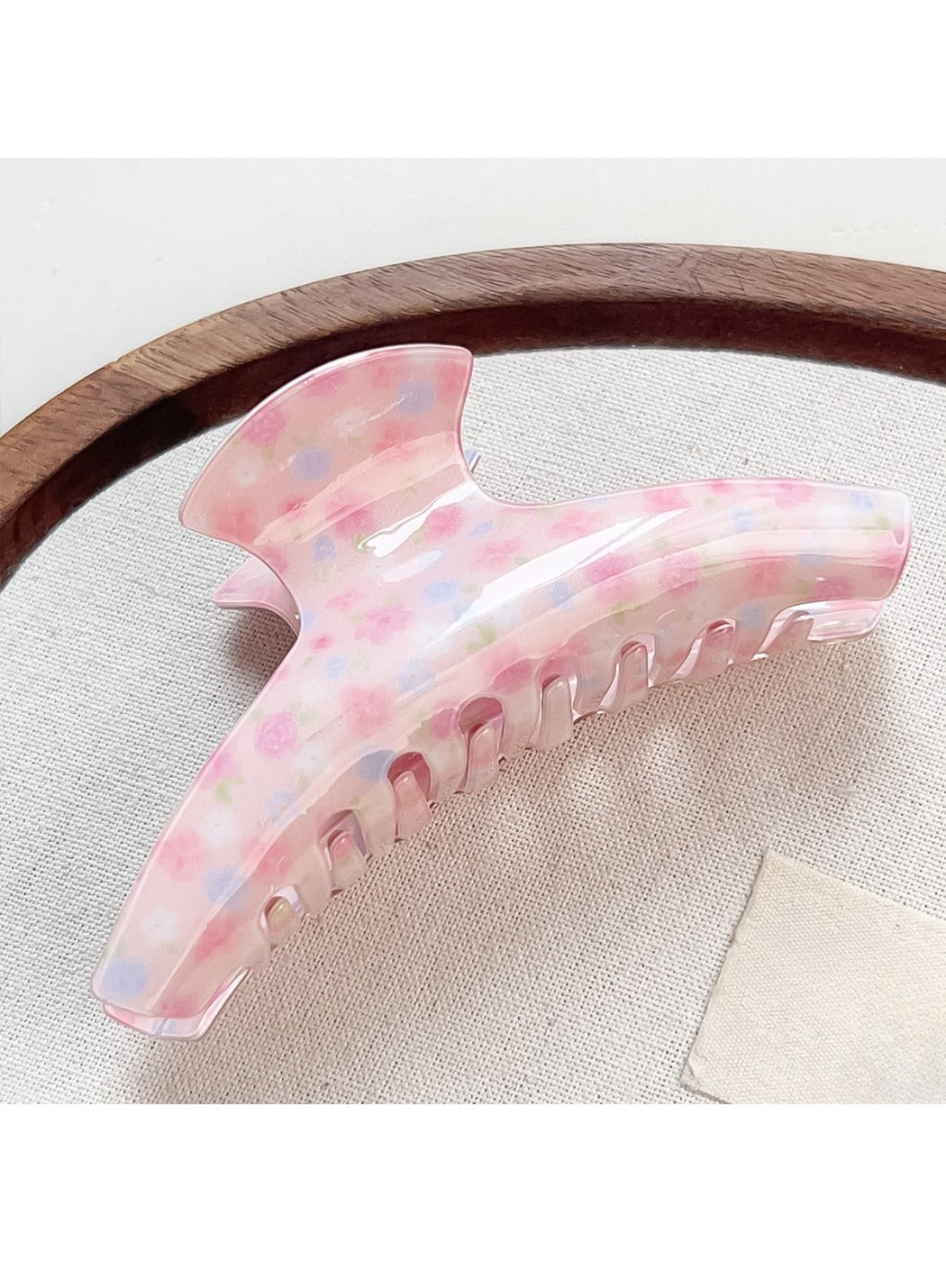 Beau Sweet Pink Floral Print Hair Claw Clip displayed on a wooden surface