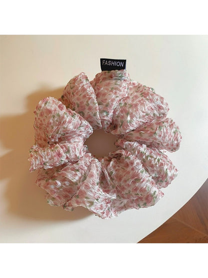 Pink floral tulle scrunchie held in hand showing size and detail