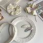 Gifty hair clip with matching beige fabric and minimalist design on white surface