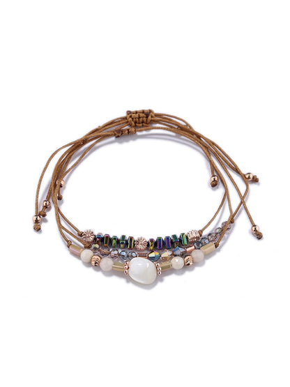 Lovra bracelet with beads and woven cord laid out on white background