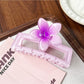 Beau square ombre flower shaped claw clip shown from bottom angle focusing on clasp details