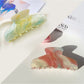 Beau gradient half moon hair claw clip held in hand showing size and shape