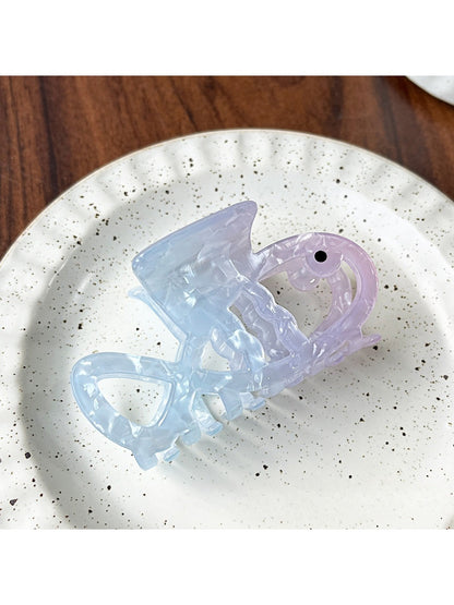 Beau claw clip with gradient blue finish placed next to matching accessories