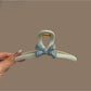 Blue acetate bow-shaped hair clip with a glossy finish