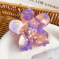 Colorful flower hair claw clip held in hand showing size and petal design